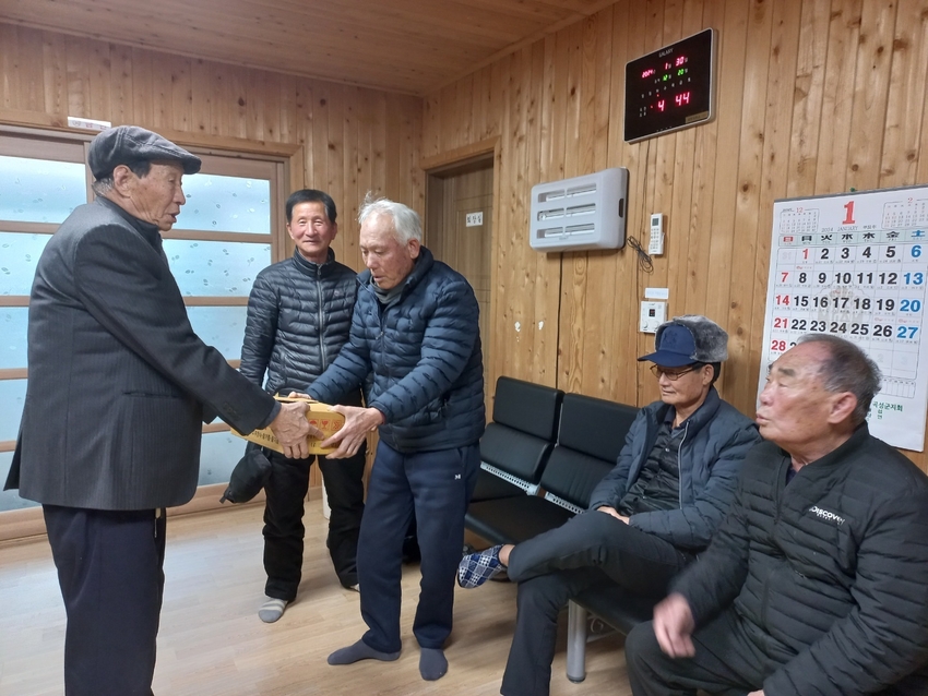 가래떡을 전달하고있는 겸면 노인회장(장영규)와 회원들