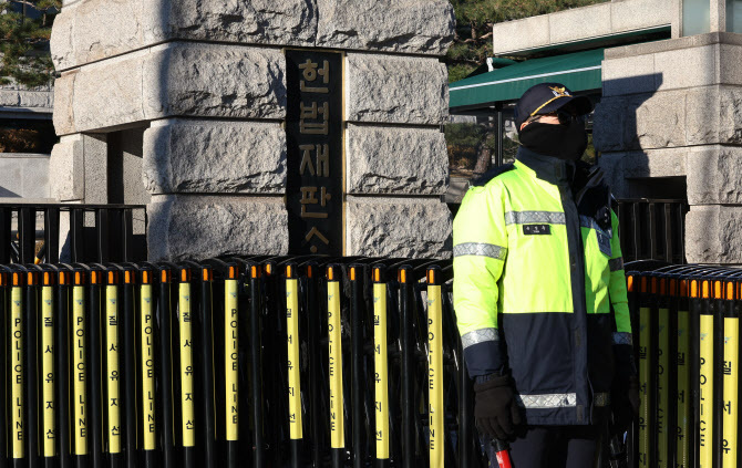 윤석열 대통령 탄핵심판 첫 변론준비기일(27일)을 앞둔 지난 22일 서울 종로구 헌법재판소 앞에서 경찰들이 출입을 통제하고 있다.