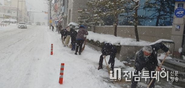 화순군이 주민 안전을 위한 제설작업에 총력을 다하고 있다. 사진은 23일 오전 군청 직원들이 농협은행 앞 인도에 쌓인 눈을 제거하고 있는 모습