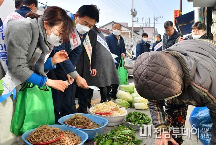전통시장에서 장을 본 김한종 장성군수가 상품권으로 물건 값을 지불하고 있다