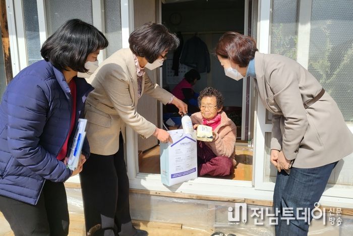 보건소 직원들이 치매고위험군 어르신 댁을 방문해 지원 물품을 전달하는 모습
