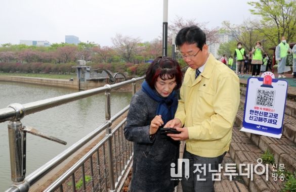 박병규 광산구청장이 6일 쌍암근린공원에서 시민과 안전캠페인을 진행하다 파손된 난간을 발견하고 직접 안전신문고에 접수하고 있다.