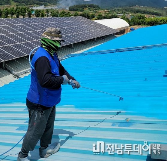 열 차단재를 축사 지붕에 도포하고 있다