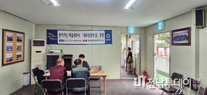 화순전통시장상인회에서 운영된 마을세무사 이세형(사진 뒤쪽)과 군민(사진 앞쪽)과의 상담 장면을 촬영한 사진