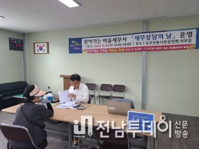 능주전통시장상인회 사무실에서 상담한 마을 세무사 염낙귀(사진 뒤쪽)와 군민(사진 앞쪽)과의 상담 장면