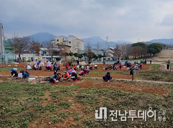 여수시 농업인학습단체가 선사유적공원 도시농업공간에 구절초를 식재하고 기념사진을 찍고 있다.