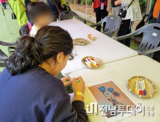 지난해 진행한 유아숲 페스티벌에서 아이와 부모가 함께 나무에 그림을 그리고 있다.