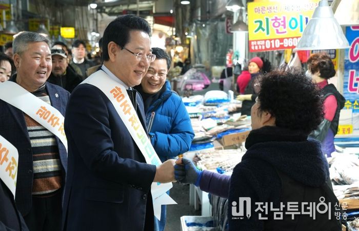 김영록 전라남도지사가 설 명절을 앞둔 15일 지역 전통시장인 광주 양동시장을 방문해 전남·광주 행정통합의 취지와 추진 방향을 설명하고 물품을 구매하며 상인들을 격려하고 있다.