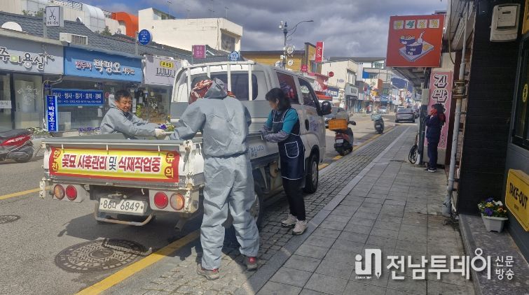 강진읍 일대 상가에 화분을 전달하고 있다.