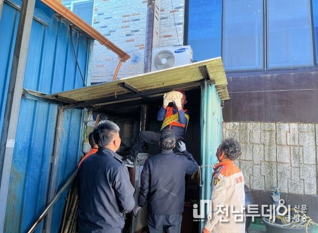 장흥소방서가 화목보일러실 천장에 자동확산소화기를 설치하고 있다.